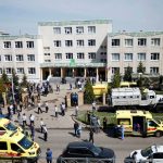 Des ambulances et des voitures de police et un camion sont garés dans une école après une fusillade à Kazan, en Russie, le mardi 11 mai 2021