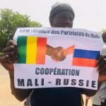 Unmanifestant malien qui tien une affiche appelant à une plus grande coopération entre le Mali et la Russie
